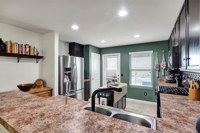 kitchen with kitchen peninsula, stainless steel fridge, and sink