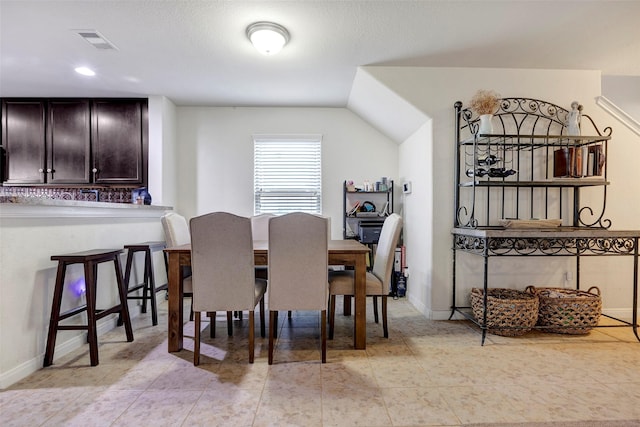 dining space with light tile patterned floors and a textured ceiling