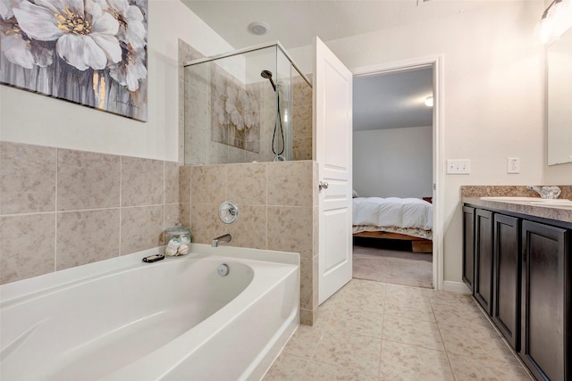 bathroom featuring tile patterned flooring, vanity, and plus walk in shower