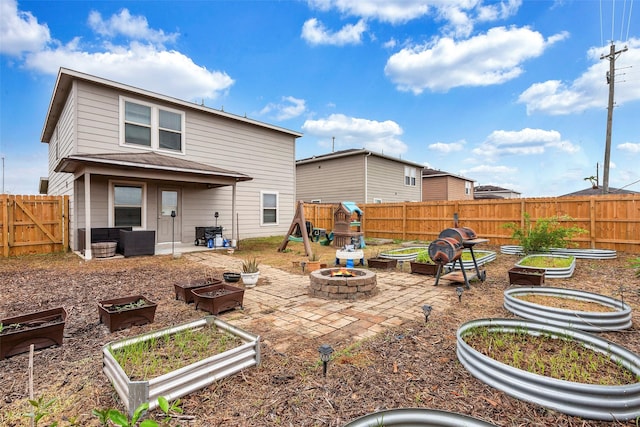 rear view of property featuring a patio area and a fire pit