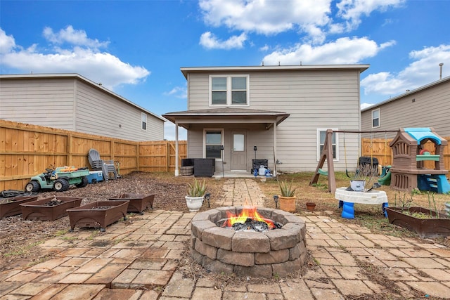 rear view of property featuring a patio area and an outdoor fire pit