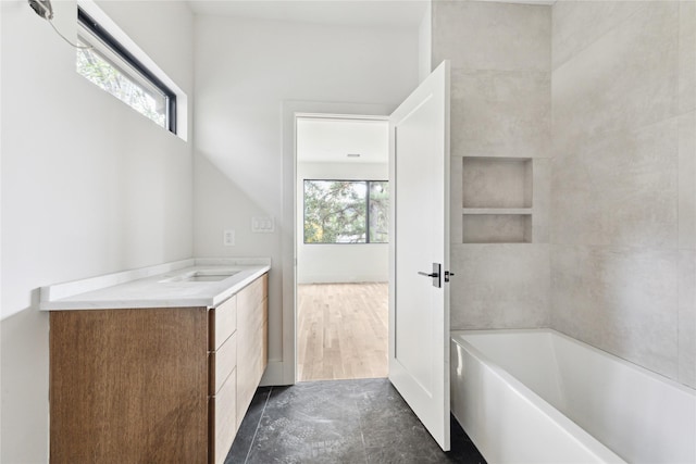 bathroom featuring vanity and a bath