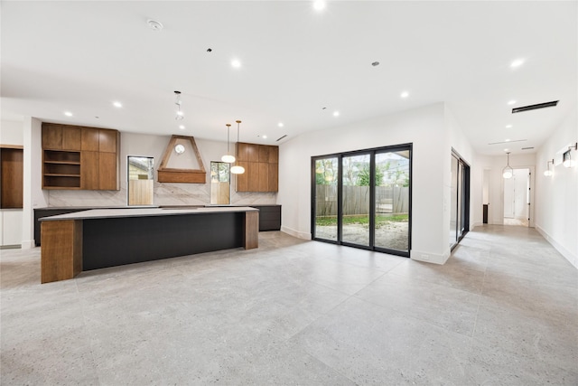 kitchen featuring decorative backsplash, a spacious island, and decorative light fixtures