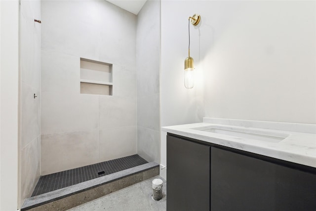 bathroom featuring vanity and tiled shower