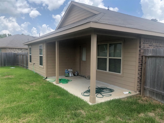 back of house with a lawn and a patio area