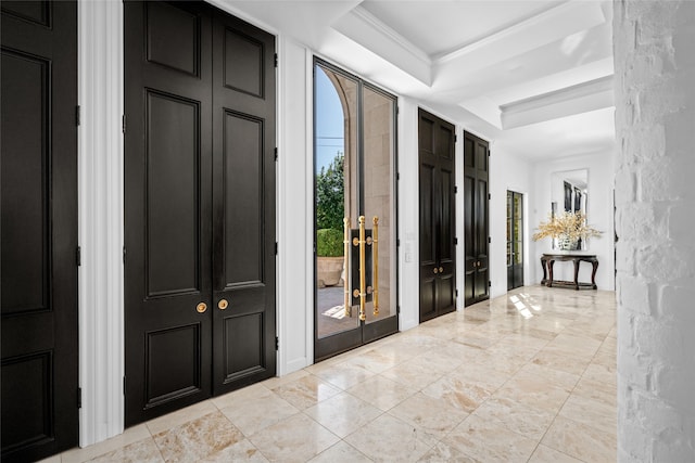 entrance foyer with french doors, a tray ceiling, and ornamental molding