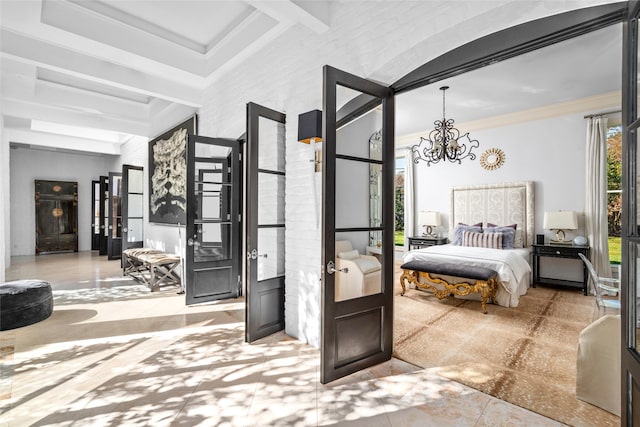 bedroom featuring beam ceiling, french doors, an inviting chandelier, brick wall, and ornamental molding