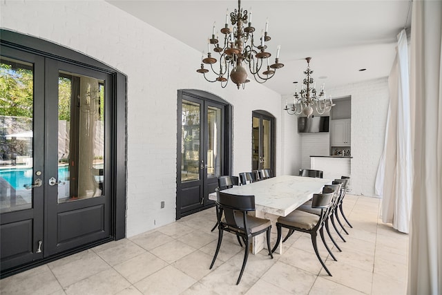 tiled dining space with french doors and a notable chandelier