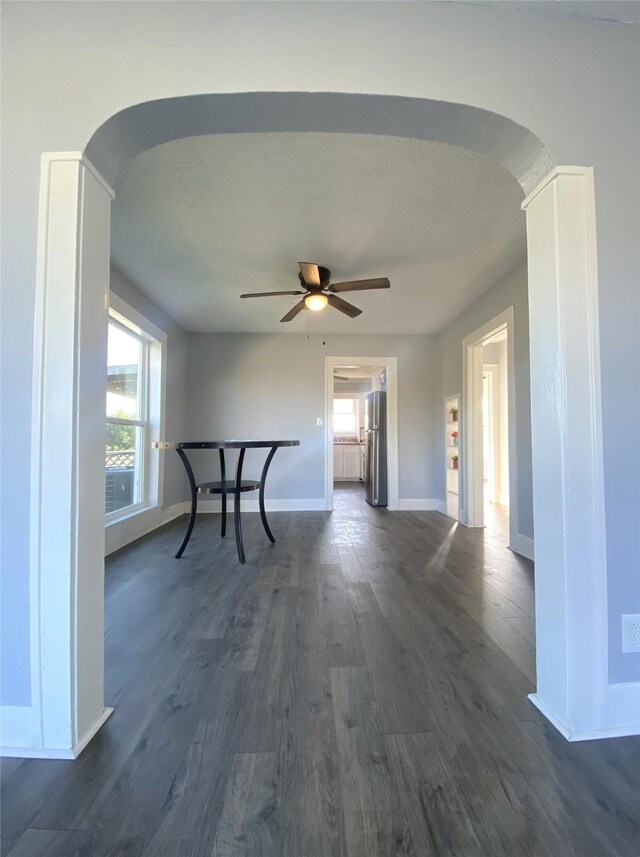 unfurnished room featuring dark hardwood / wood-style floors, ceiling fan, and decorative columns