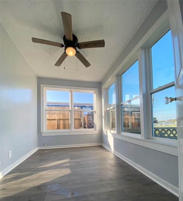 unfurnished sunroom featuring a wealth of natural light and ceiling fan