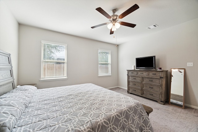 carpeted bedroom with multiple windows and ceiling fan