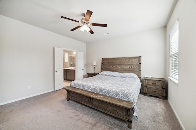 bedroom with connected bathroom, ceiling fan, and light carpet