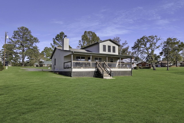 rear view of property featuring a lawn and covered porch