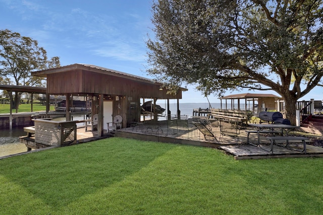 dock area with a water view and a lawn