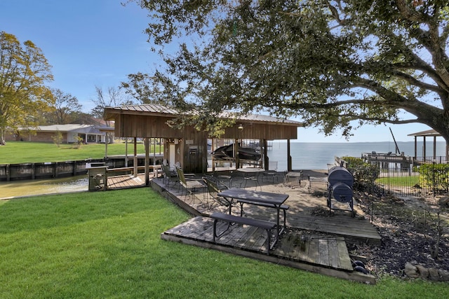 dock area featuring a lawn and a water view