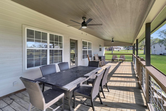 wooden terrace with ceiling fan and a lawn