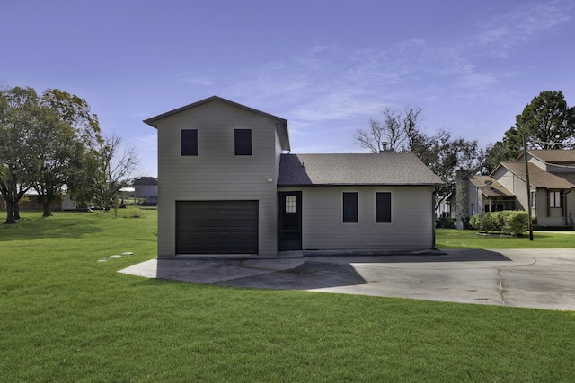 back of house featuring a garage and a yard