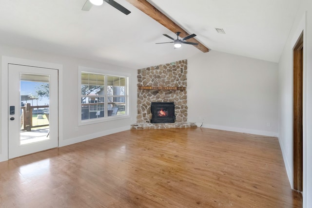 unfurnished living room featuring ceiling fan, a fireplace, lofted ceiling with beams, and hardwood / wood-style flooring