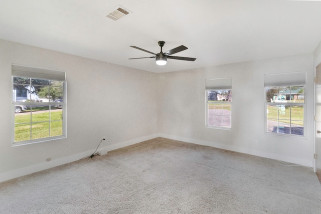 empty room featuring carpet flooring, a wealth of natural light, and ceiling fan