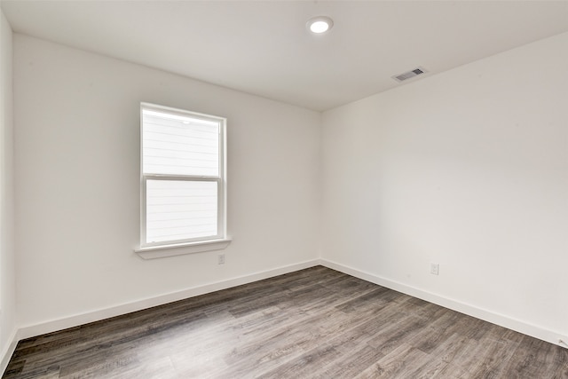 unfurnished room with dark wood-type flooring