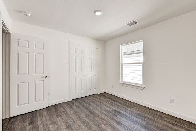 unfurnished bedroom with wood-type flooring and a closet