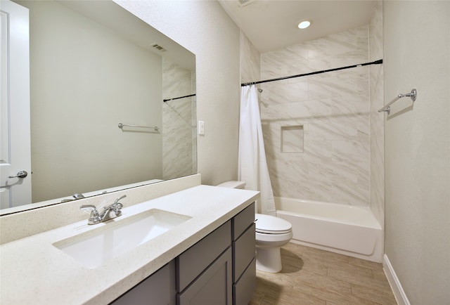 full bathroom featuring hardwood / wood-style flooring, vanity, shower / bath combination with curtain, and toilet