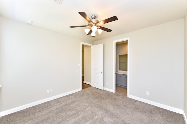 unfurnished bedroom featuring ensuite bath, ceiling fan, and light carpet