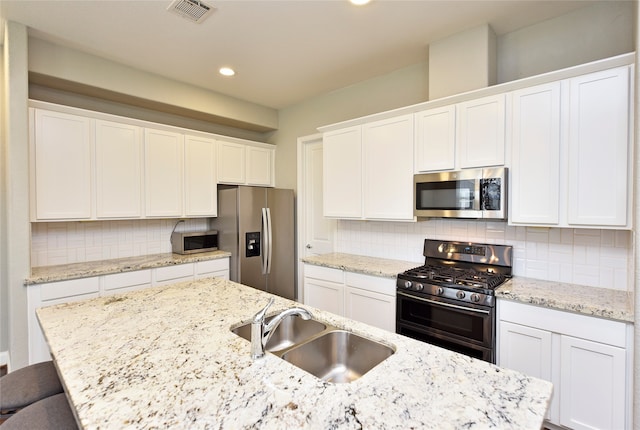 kitchen with backsplash, white cabinetry, sink, and appliances with stainless steel finishes