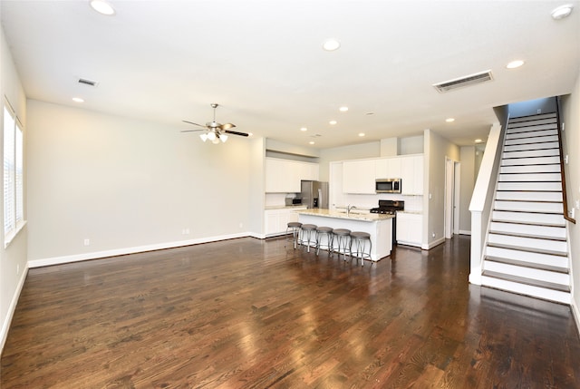 unfurnished living room featuring dark hardwood / wood-style floors and ceiling fan