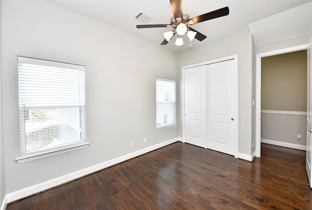 unfurnished bedroom with ceiling fan, a closet, and dark hardwood / wood-style floors