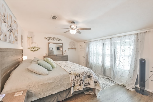 bedroom with ceiling fan, dark hardwood / wood-style floors, and vaulted ceiling