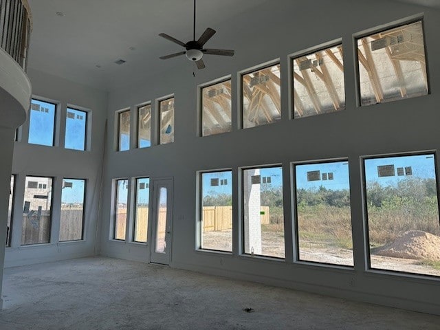 interior space featuring ceiling fan and a towering ceiling