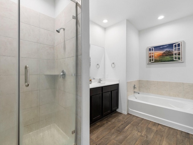 bathroom featuring hardwood / wood-style flooring, vanity, and shower with separate bathtub