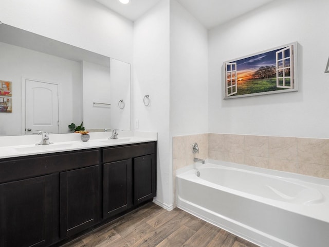 bathroom with a washtub, hardwood / wood-style floors, and vanity