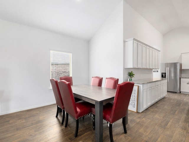 dining area featuring lofted ceiling and dark wood-type flooring