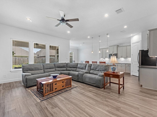 living room featuring light hardwood / wood-style floors and ceiling fan