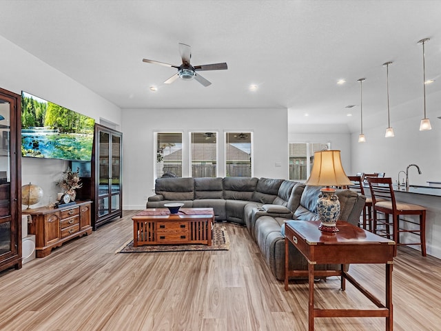 living room with ceiling fan and light wood-type flooring