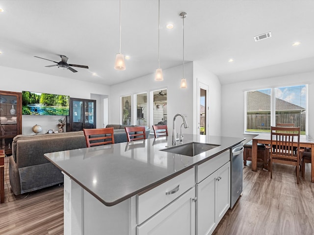 kitchen featuring white cabinetry, sink, an island with sink, and ceiling fan