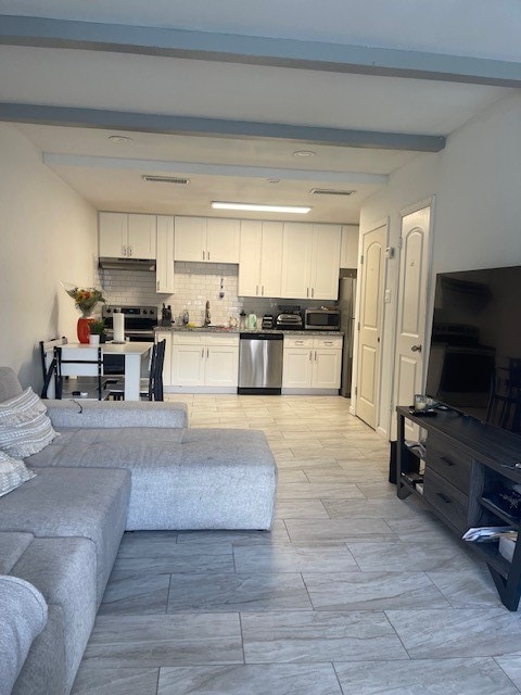 living room with beamed ceiling and sink