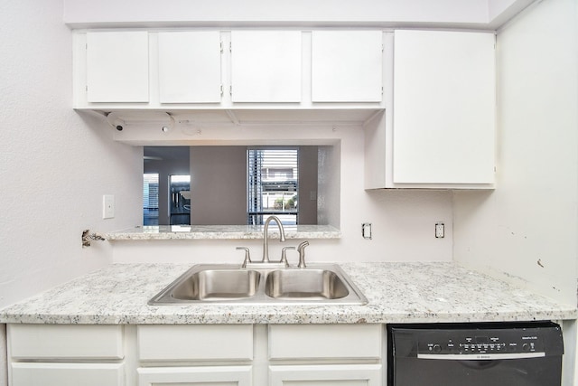 kitchen with white cabinetry, dishwasher, light stone counters, and sink