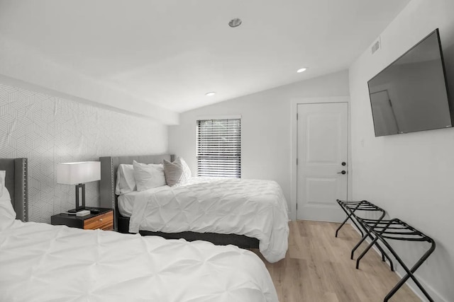 bedroom with lofted ceiling and light hardwood / wood-style flooring