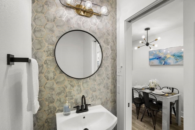 bathroom featuring tile walls, sink, an inviting chandelier, and hardwood / wood-style flooring