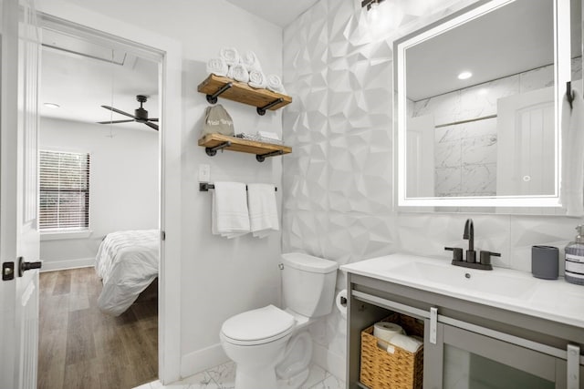 bathroom with ceiling fan, vanity, tile walls, and toilet