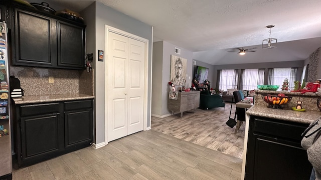 kitchen featuring a textured ceiling, light wood-type flooring, tasteful backsplash, and ceiling fan