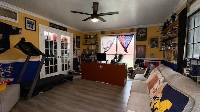 interior space featuring ceiling fan, wood-type flooring, crown molding, and french doors