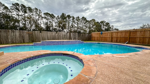 view of swimming pool with an in ground hot tub