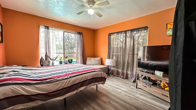 bedroom featuring a textured ceiling, light hardwood / wood-style flooring, and ceiling fan