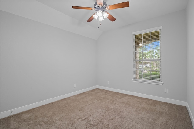 empty room featuring ceiling fan, lofted ceiling, and light carpet