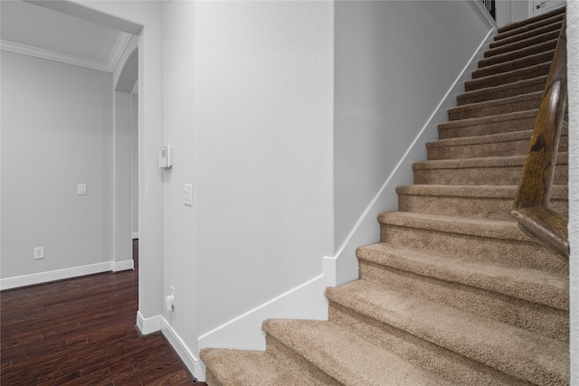 stairs featuring wood-type flooring and ornamental molding