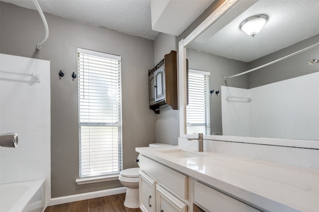 full bathroom with shower / bathtub combination, vanity, a textured ceiling, hardwood / wood-style floors, and toilet